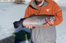 Ice fishing on frozen water with local guide