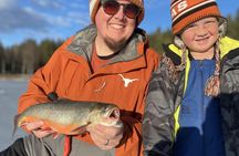 Ice fishing on frozen water with local guide