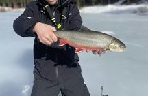 Ice fishing on frozen water with local guide