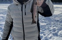 Ice fishing on frozen water with local guide