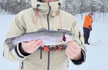 Ice fishing on frozen water with local guide