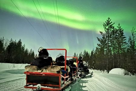 Northern lights sledge ride by snowmobile