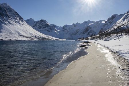 Tromso fjords road trip with fire in grill cabin by the beach.