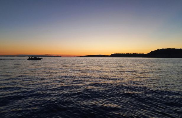 Golden hour boat tour with sunset views of Macarella in Menorca
